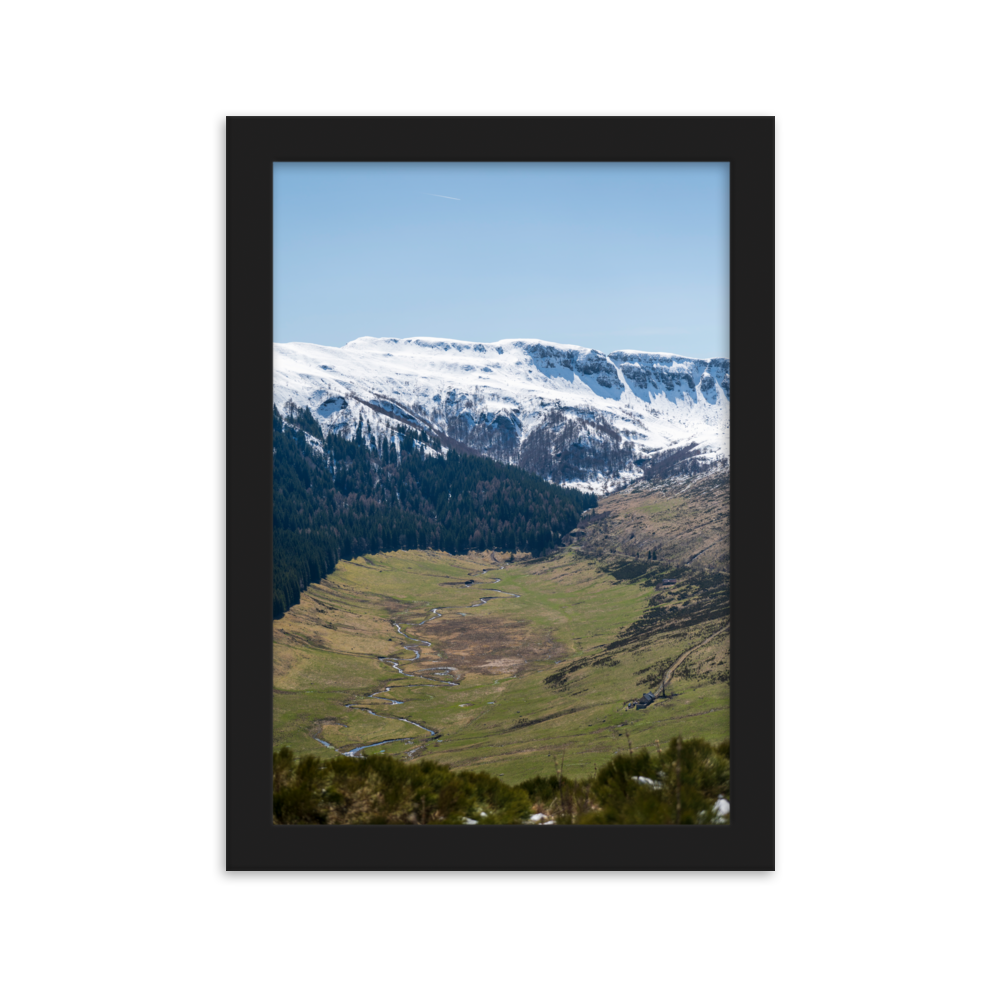 Poster d'une vallée verdoyante avec des montagnes enneigées en arrière-plan, situées dans le Cantal