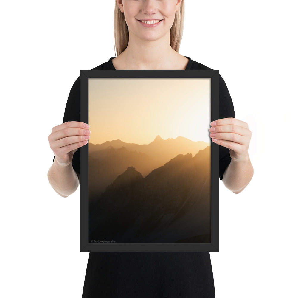 Lever du soleil illuminant des montagnes imposantes, photographié par Brad_explographie, présenté dans un cadre élégant.