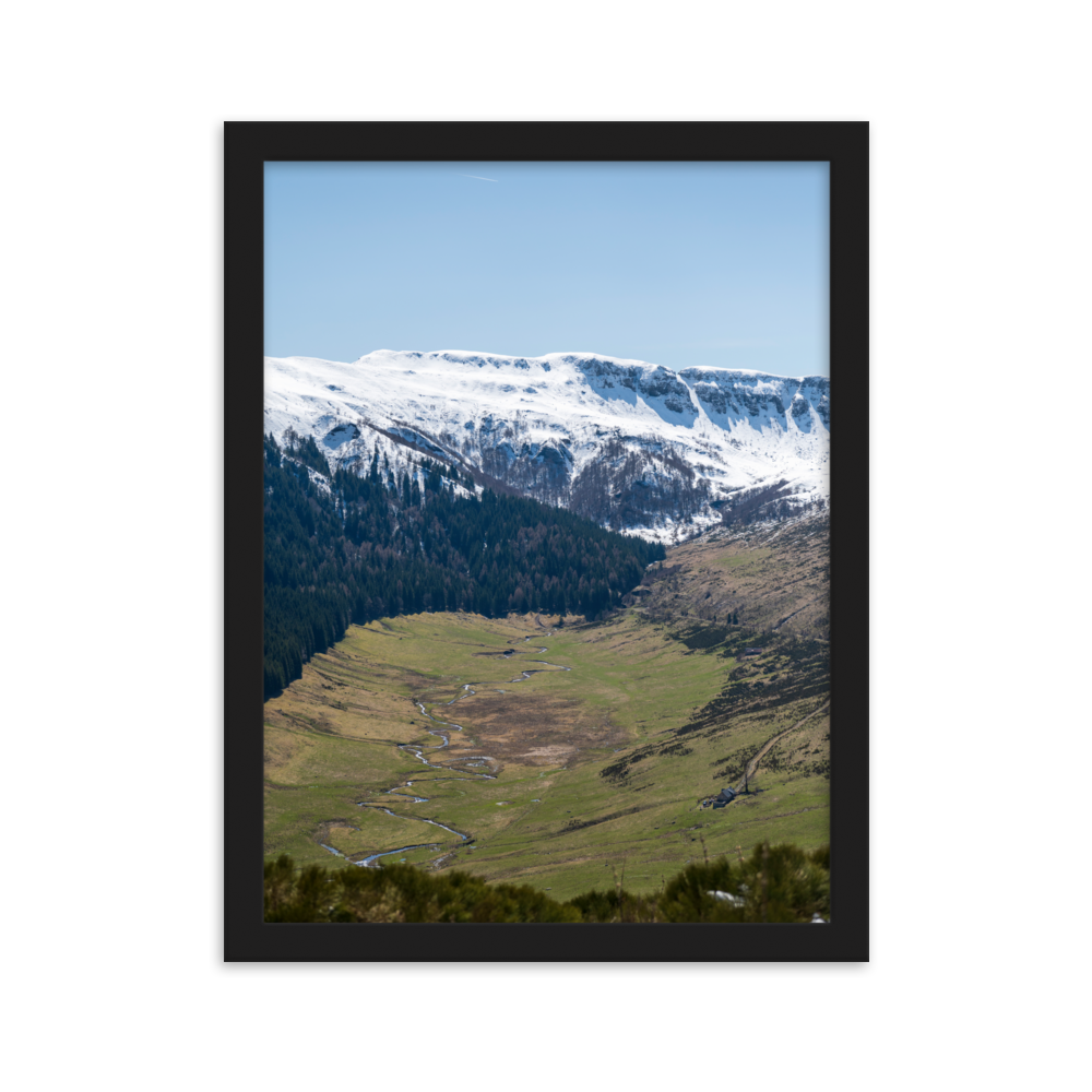 Poster d'une vallée verdoyante avec des montagnes enneigées en arrière-plan, situées dans le Cantal