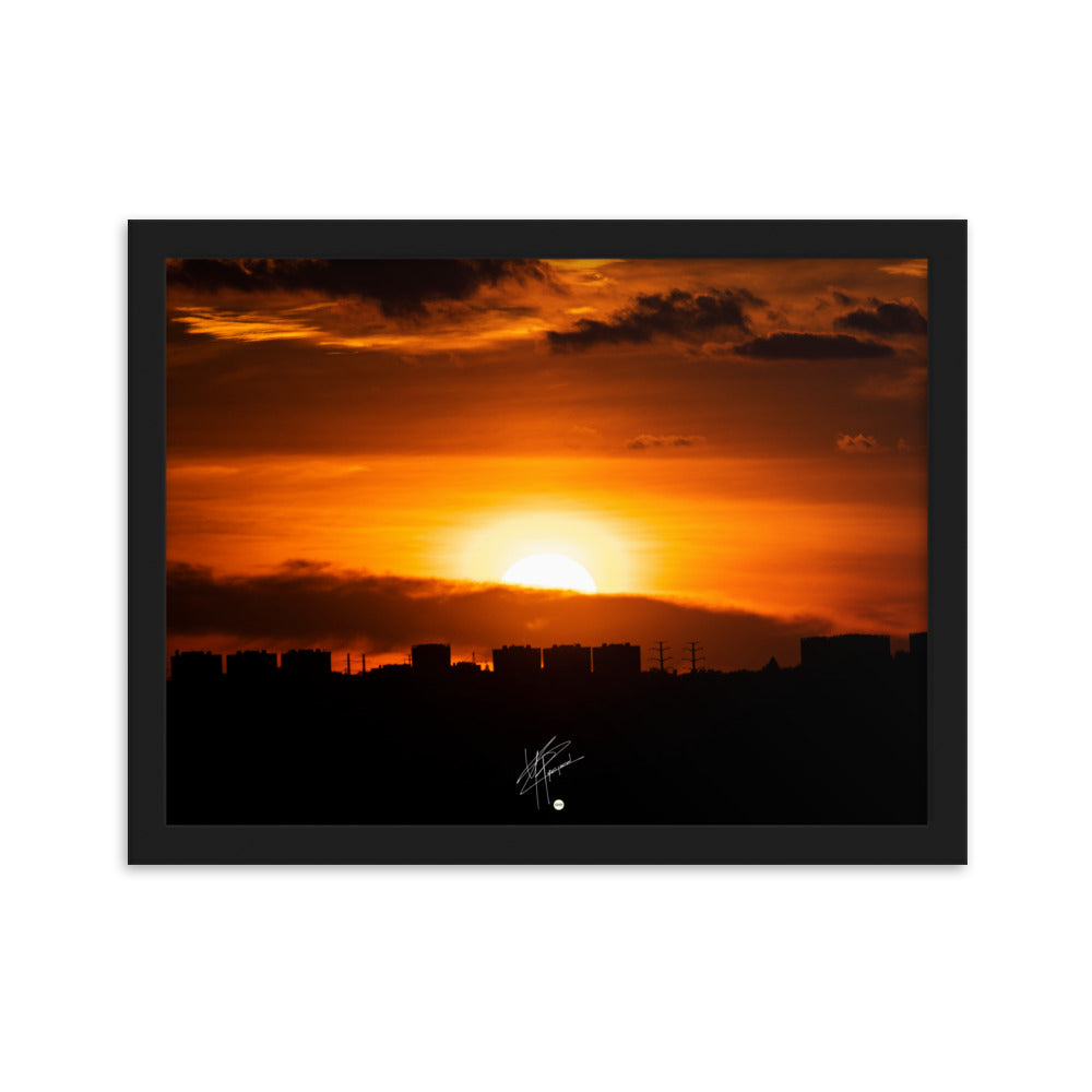 Vue panoramique d'une ville au coucher du soleil, où les bâtiments se découpent majestueusement contre le ciel orangé, évoquant calme et sérénité.
