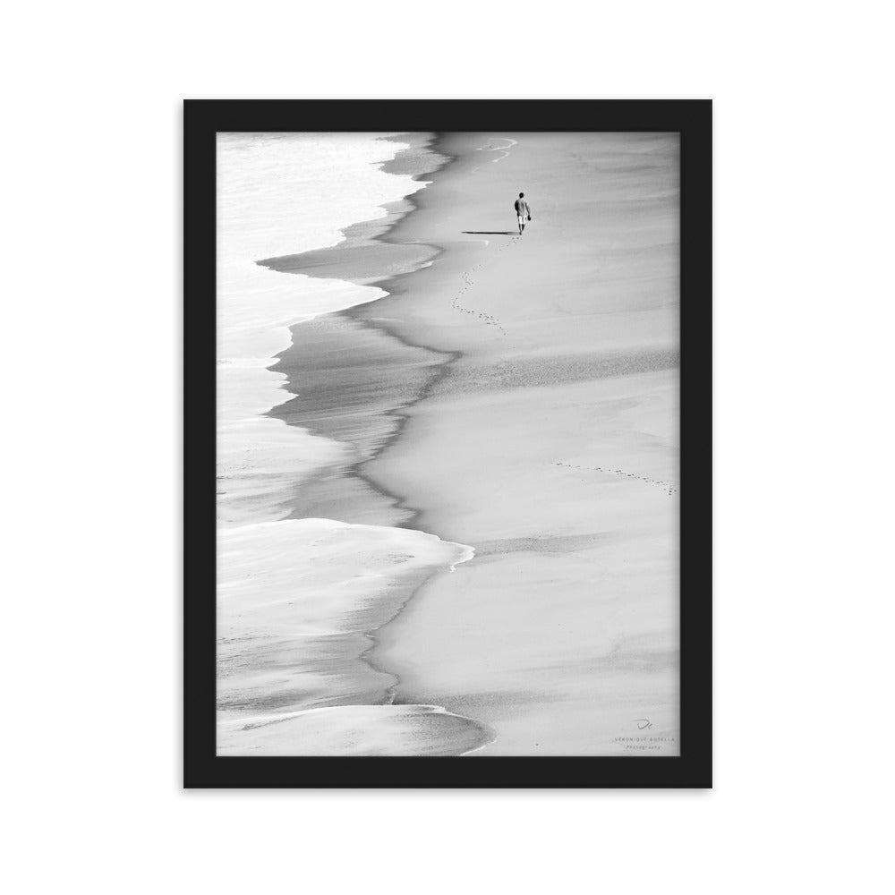 Poster encadré 'Le marcheur solitaire' en noir et blanc, capturant une silhouette solitaire sur une plage paisible, photographié par Veronique Botella.