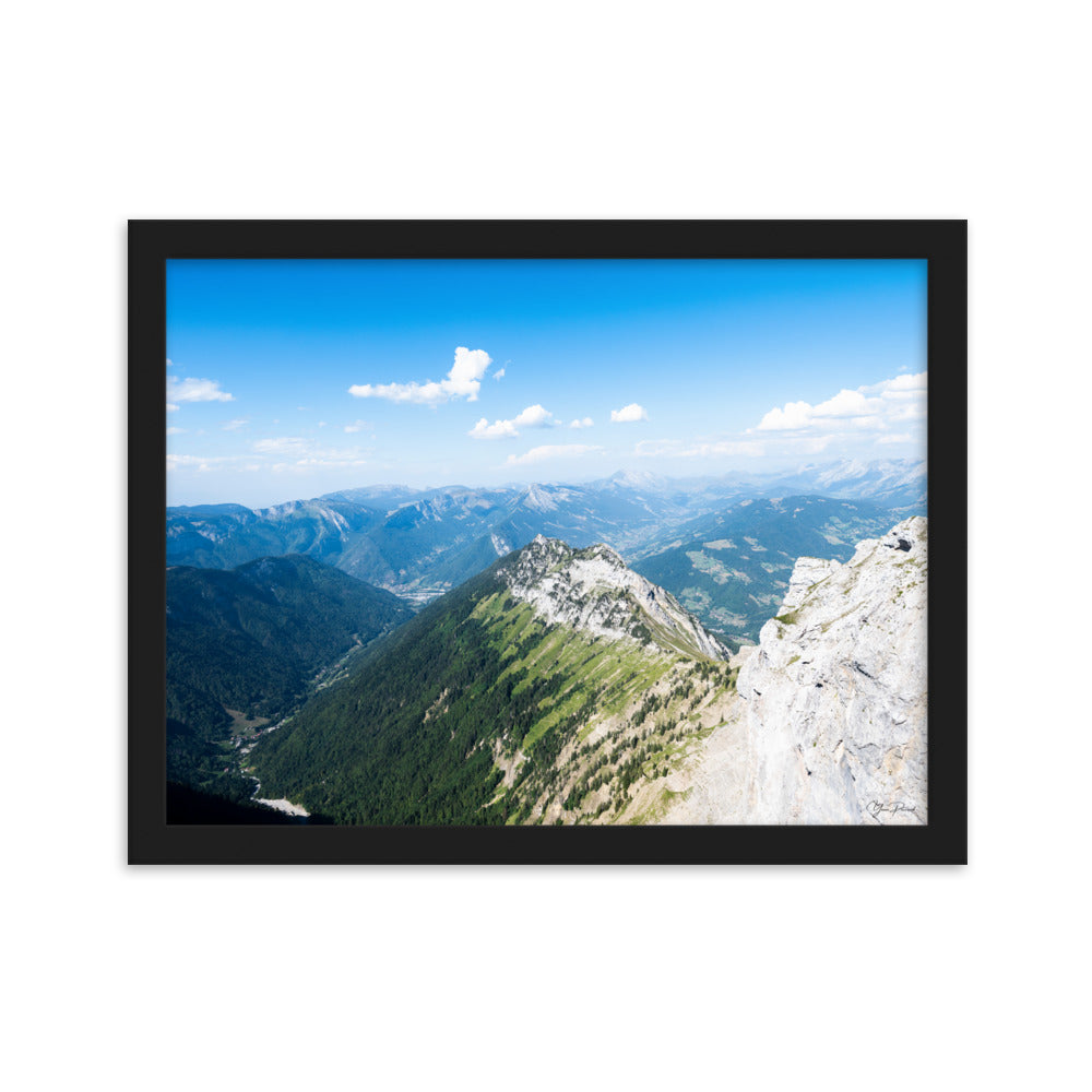 Photographie panoramique des Alpes avec montagnes robustes, vallées verdoyantes, nuages flottants et ciel bleu azur.