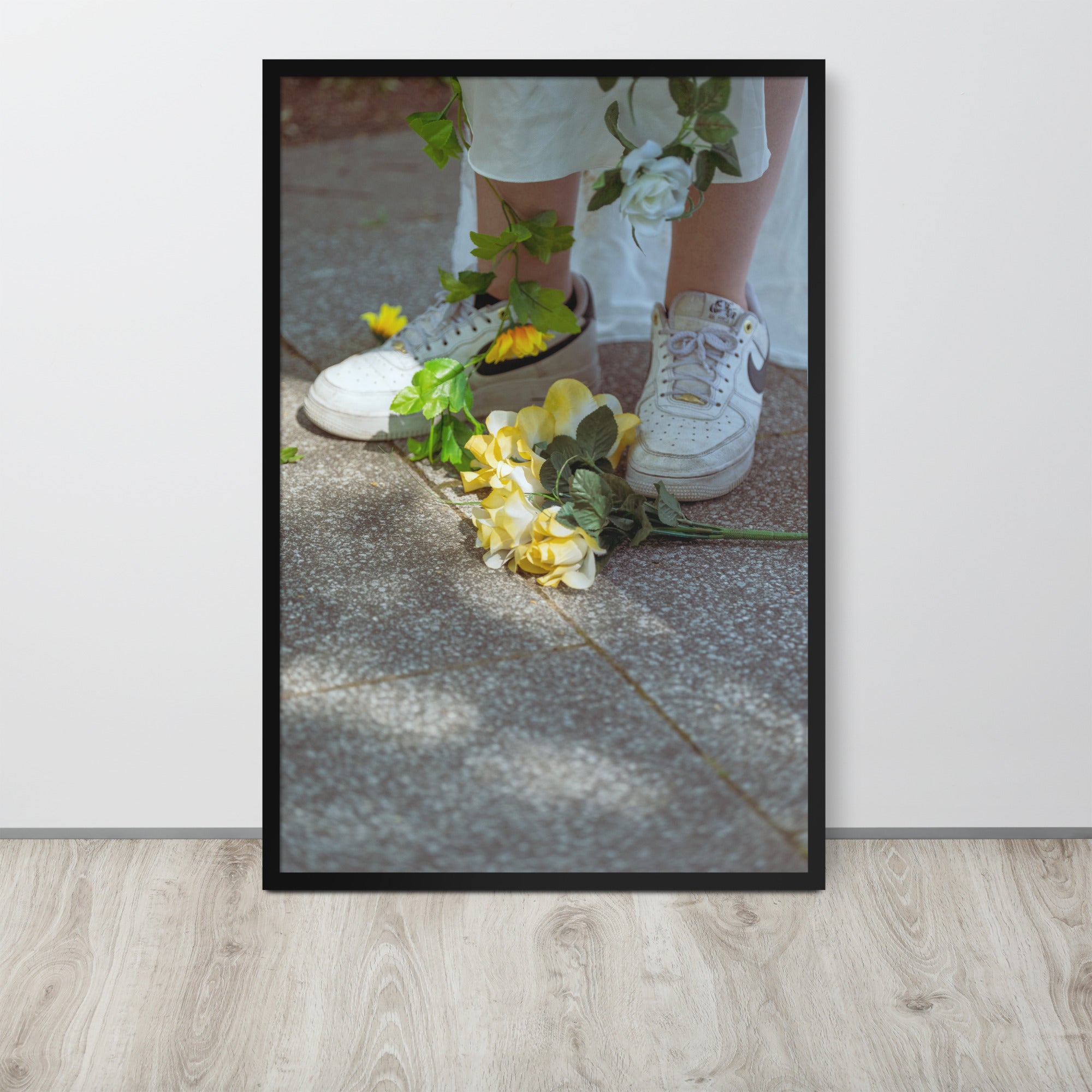 Poster encadré 'Flowers Nike' montrant des fleurs jaunes aux pieds d'une femme en blanc portant des Nike Air Force
