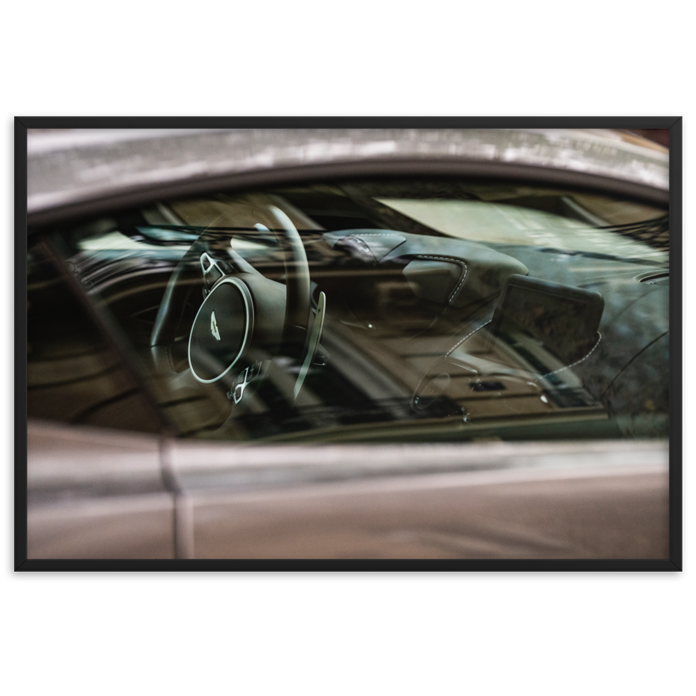 Le poster "Aston Martin Vantage N02" met en scène l'intérieur luxueux d'une Aston Martin Vantage. Capturée à travers la fenêtre, cette photographie met en valeur le tableau de bord en cuir noir, les surpiqûres claires et le volant élégant du véhicule. Ce poster est parfait pour les passionnés d'automobile et d'élégance britannique.