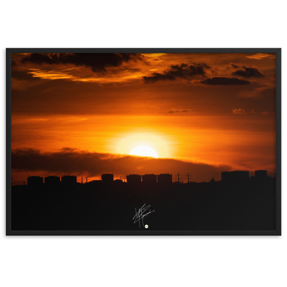 Vue panoramique d'une ville au coucher du soleil, où les bâtiments se découpent majestueusement contre le ciel orangé, évoquant calme et sérénité.