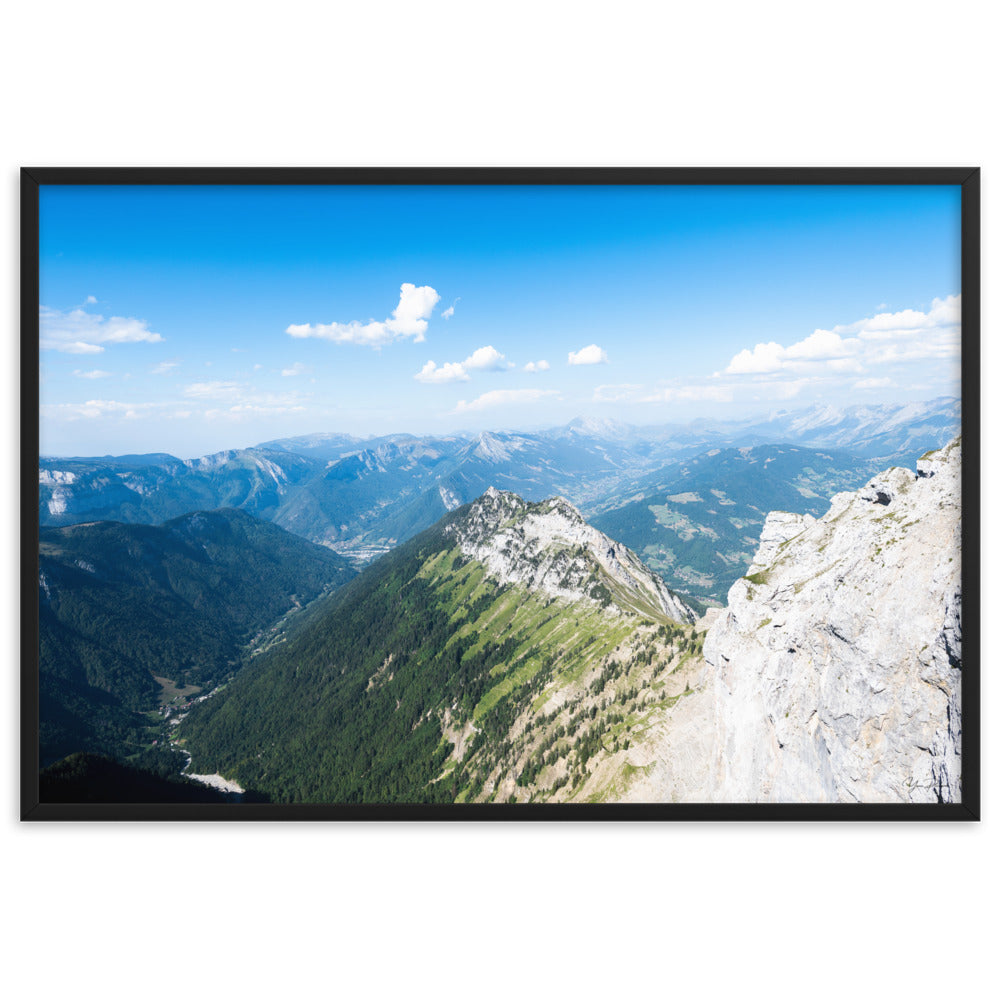 Photographie panoramique des Alpes avec montagnes robustes, vallées verdoyantes, nuages flottants et ciel bleu azur.