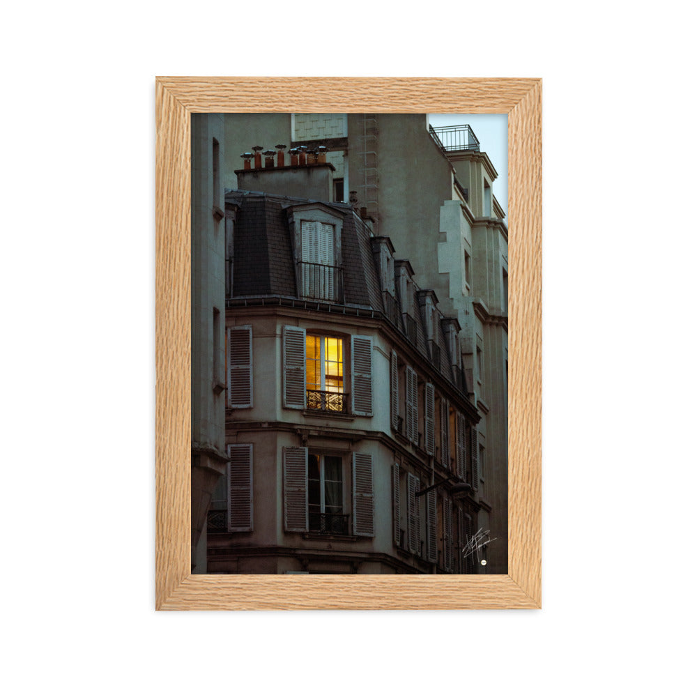 Photographie nocturne d'un bâtiment parisien vintage. Une fenêtre illuminée projette une lumière douce et chaleureuse, évoquant l'intimité d'un foyer parisien.