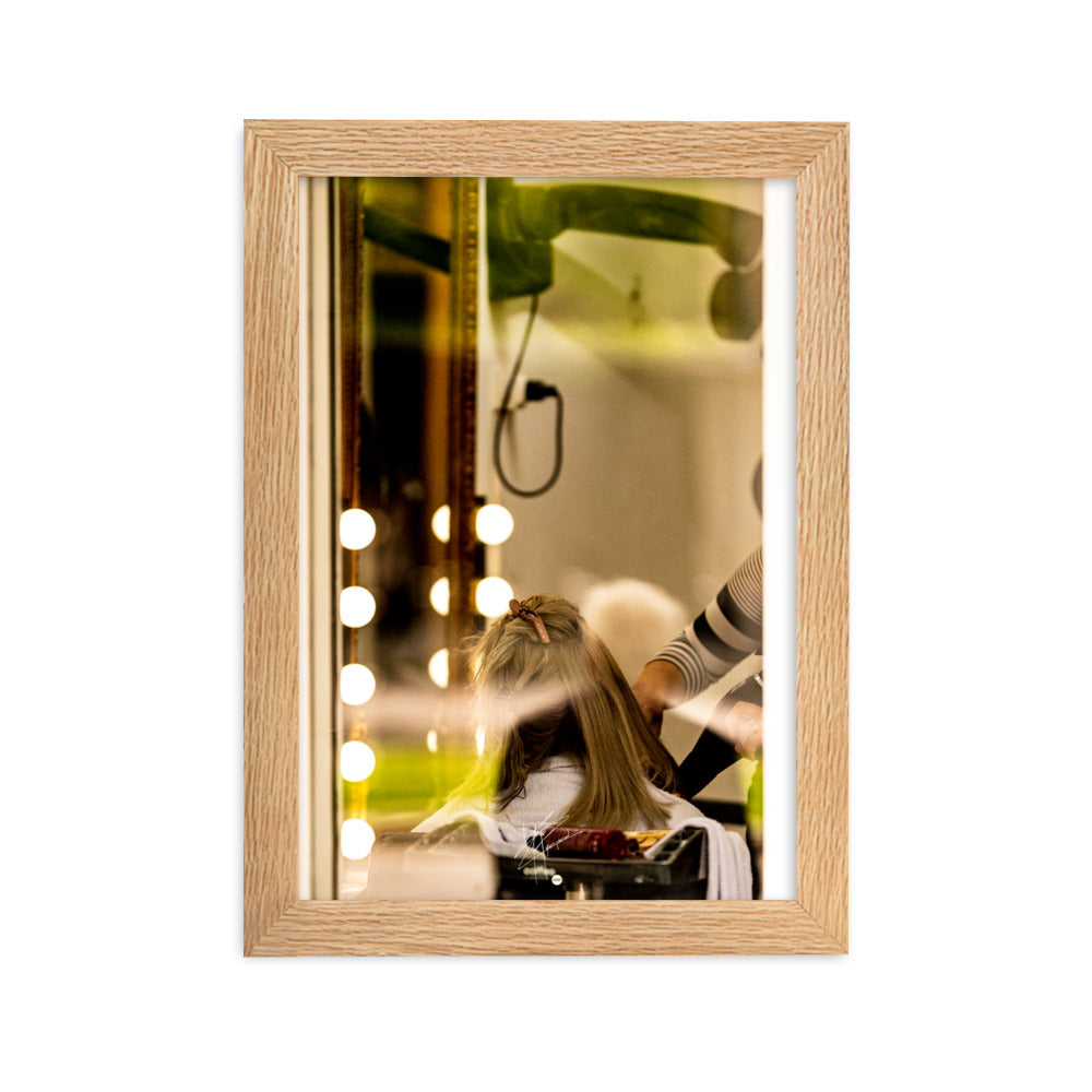 Photographie d'une scène à travers la vitre d'un salon de coiffure, révélant un moment ordinaire mais expressif d'une coiffeuse en plein travail.