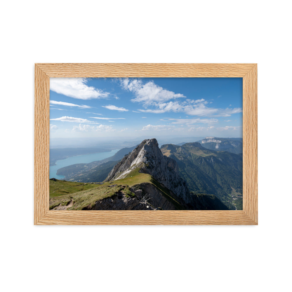 Vue aérienne du Col du Varo avec les montagnes rocheuses en avant-plan et le Lac d'Annecy en arrière-plan, encadré en chêne.