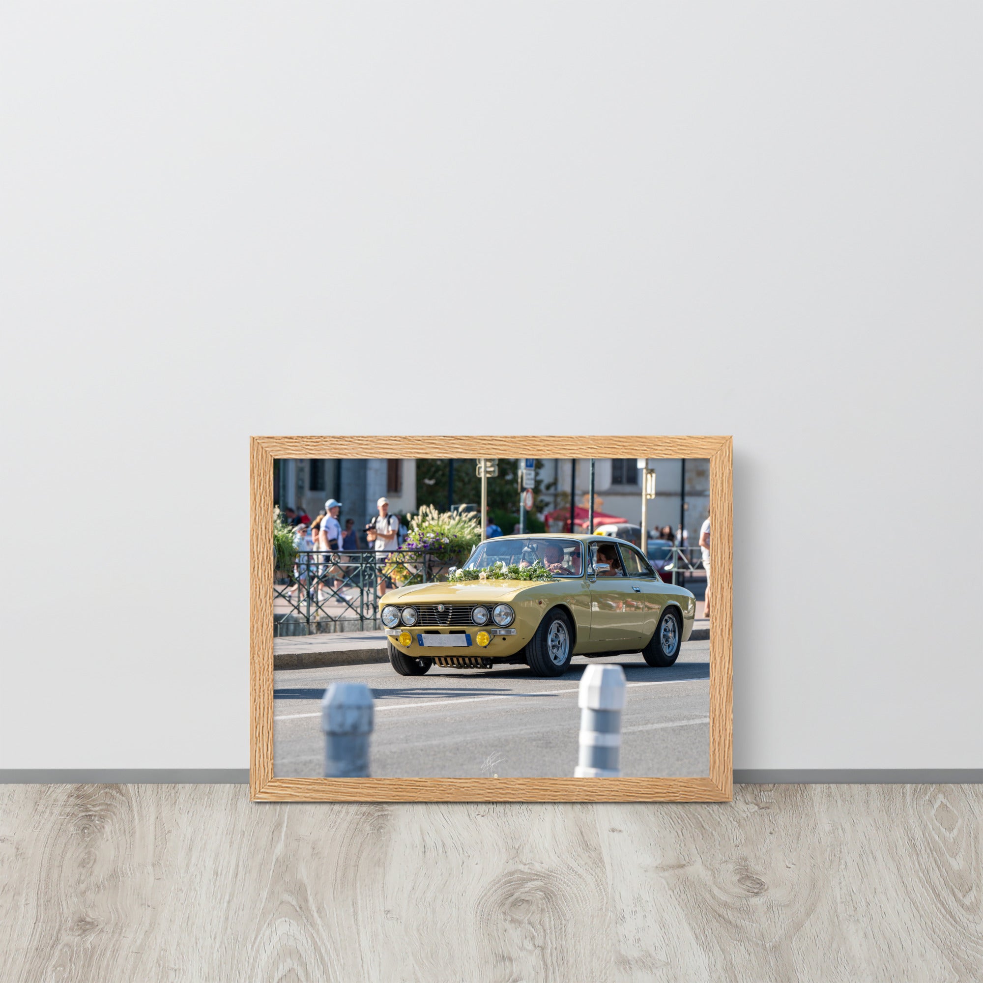 Photographie en angle de la voiture Alpha Romeo GTV, mise en valeur par sa teinte jaune vibrante et sa forme emblématique, stationnée élégamment dans une rue de ville.
