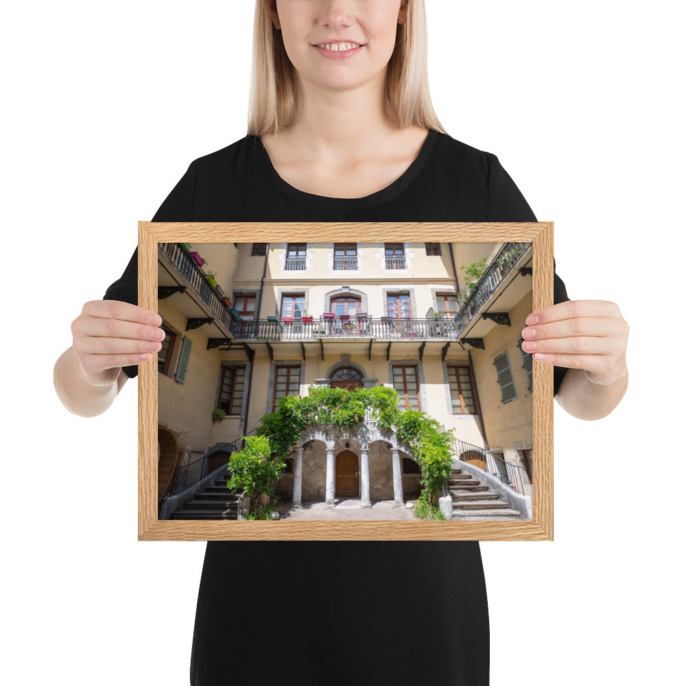 Photographie d'un bâtiment traditionnel italien avec escaliers en spirale et plantes suspendues, encadrée en chêne massif.