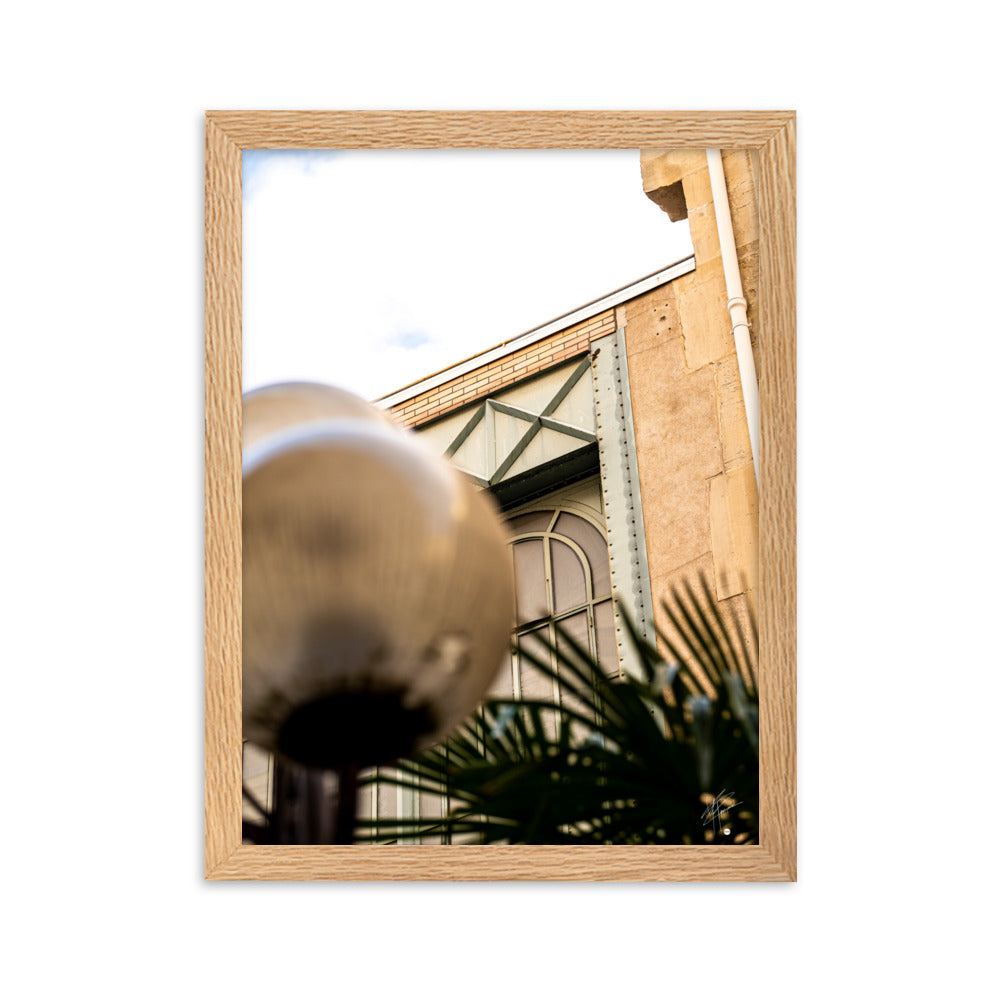 Photographie mettant en lumière l'architecture marocaine avec sa pierre jaune, une silhouette de palmier et des éléments industriels, évoquant un voyage exotique.