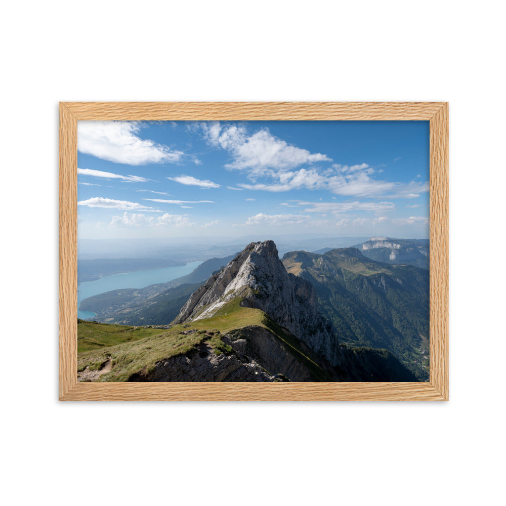 Vue aérienne du Col du Varo avec les montagnes rocheuses en avant-plan et le Lac d'Annecy en arrière-plan, encadré en chêne.