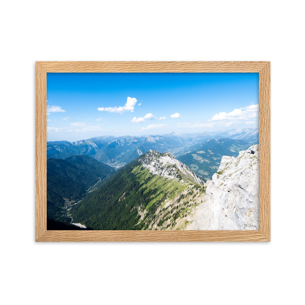 Photographie panoramique des Alpes avec montagnes robustes, vallées verdoyantes, nuages flottants et ciel bleu azur.