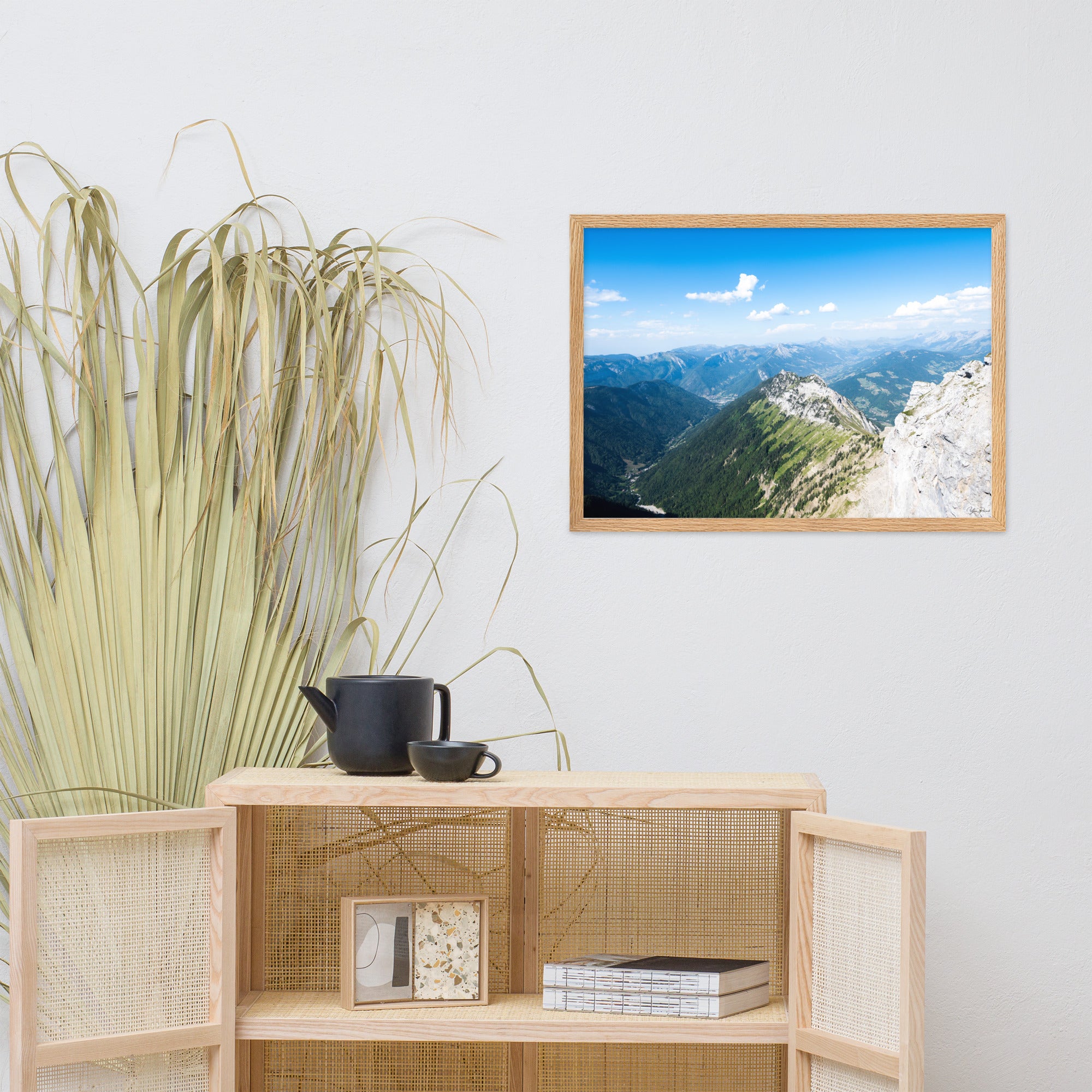 Photographie panoramique des Alpes avec montagnes robustes, vallées verdoyantes, nuages flottants et ciel bleu azur.