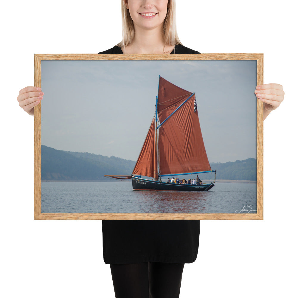Affiche 'Le cap sur Brest', une image maritime pittoresque par Adrien Louraco, montrant un bateau à voile rouge naviguant à travers le port de Brest, combinant beauté naturelle et charme culturel breton dans une œuvre d'art mural inspirante.
