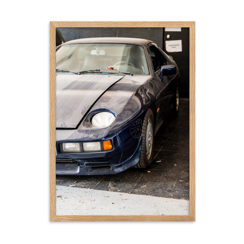 Poster d'une photographie d'une Porsche 928 poussiéreuse stationnée dans un coin discret.