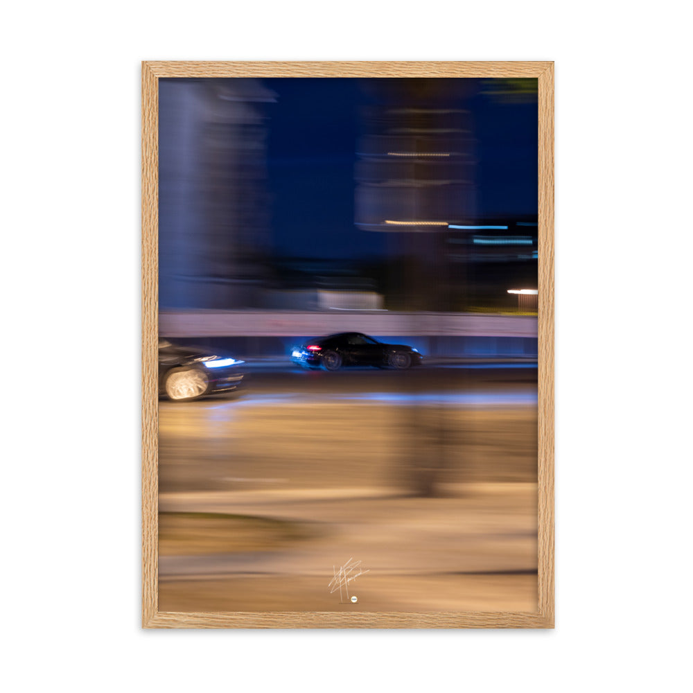 Photographie de la Place de l'Étoile capturant une Porsche au milieu de lumières floues de la circulation. La technique de pause longue crée un contraste saisissant entre mouvement et immobilité, illustrant l'effervescence parisienne.