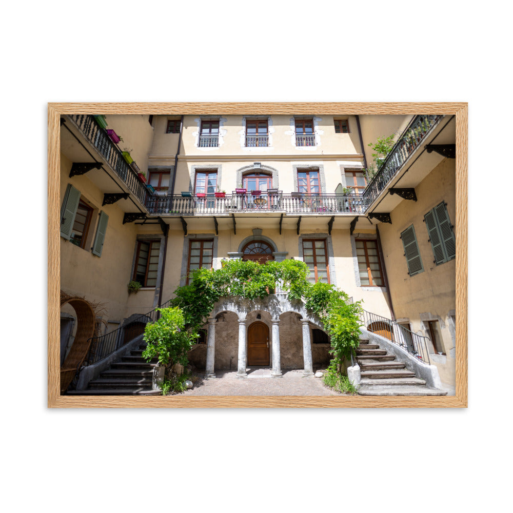 Photographie d'un bâtiment traditionnel italien avec escaliers en spirale et plantes suspendues, encadrée en chêne massif.