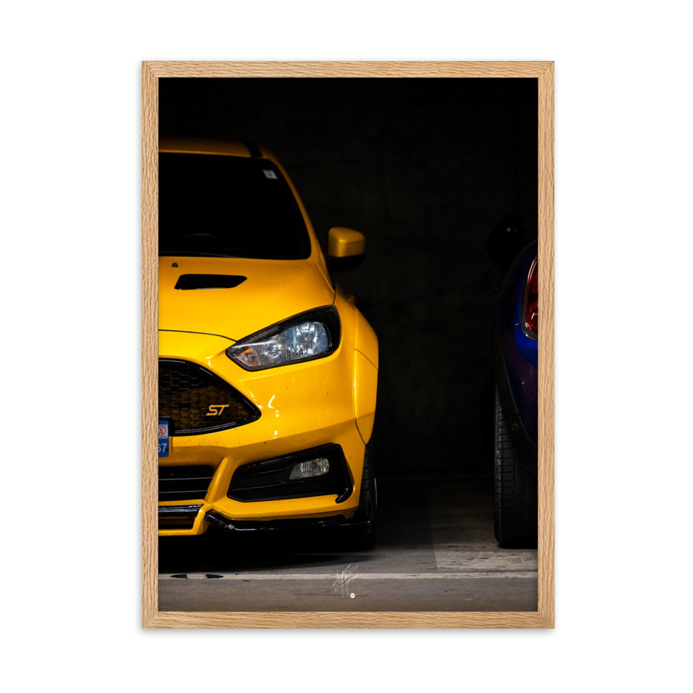 Ford Focus ST en teinte jaune brillante, éclairée dans un parking souterrain sombre, encadrée en bois de chêne.