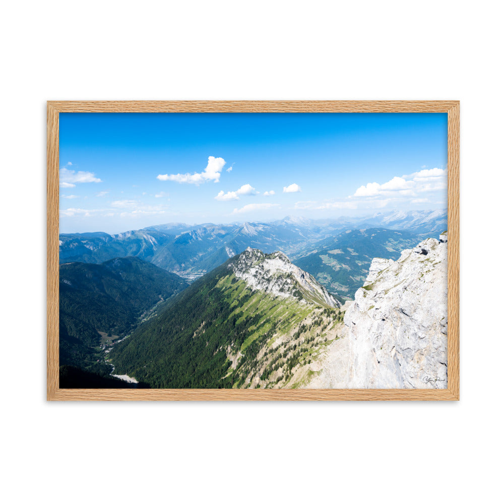 Photographie panoramique des Alpes avec montagnes robustes, vallées verdoyantes, nuages flottants et ciel bleu azur.