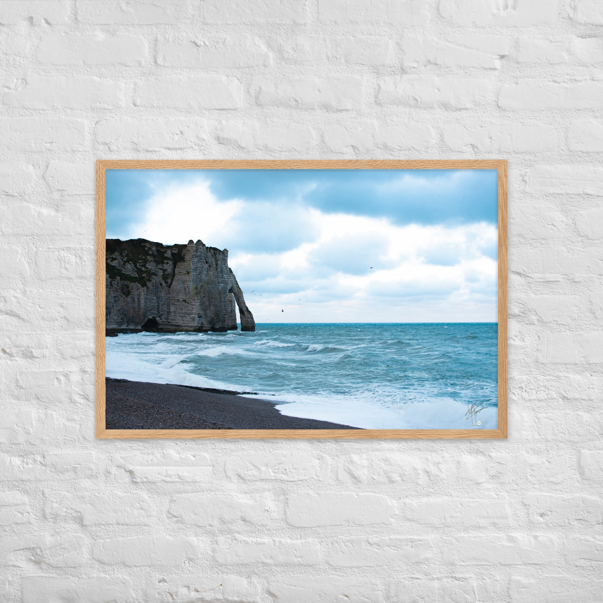 Photographie apaisante de la plage d'Etretat, où la mer caresse le rivage sous un ciel clair. Une représentation parfaite de la tranquillité et de la beauté naturelle de la côte normande.