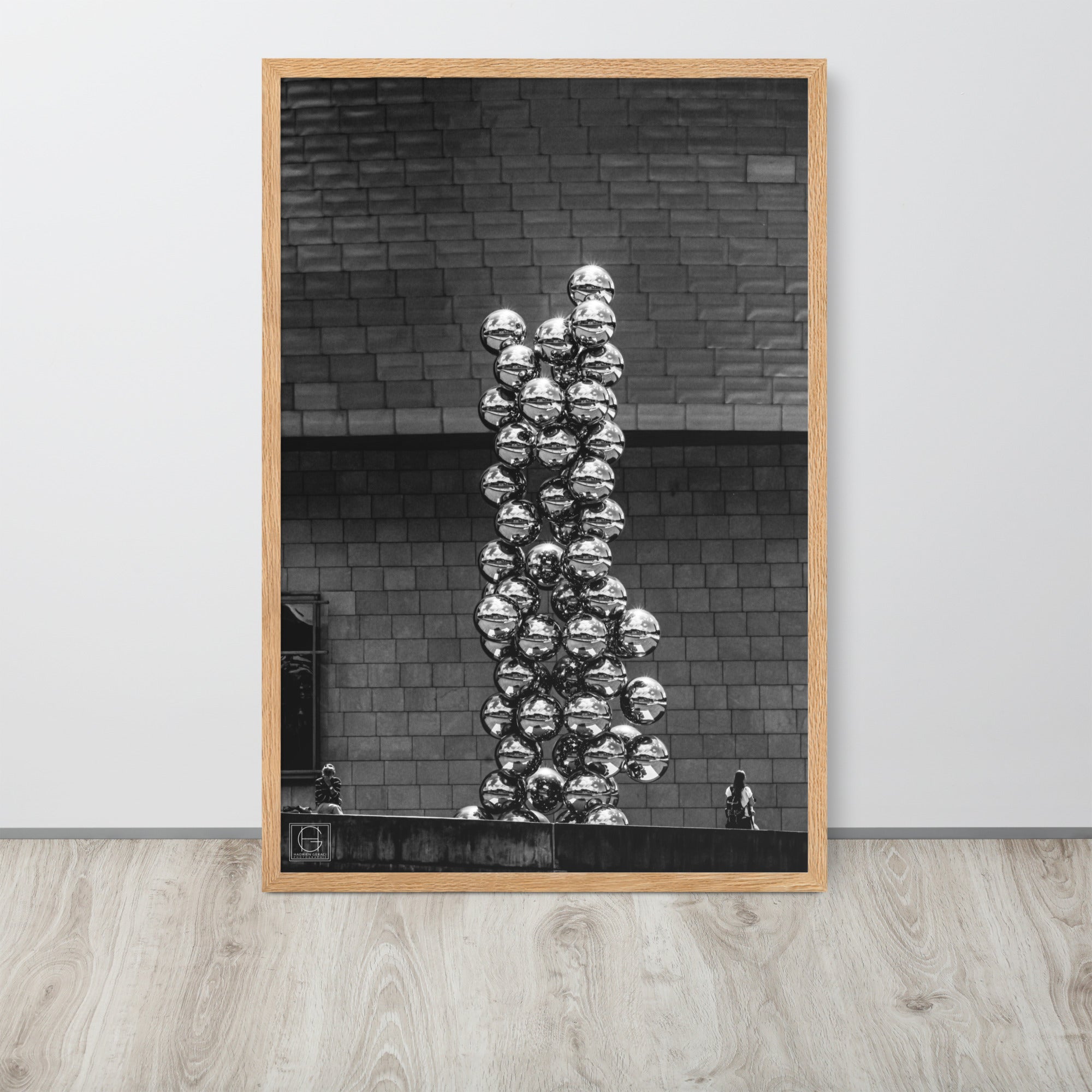 Photographie encadrée 'Le Grand Arbre et l’Œil N02' par Hadrien Geraci, mettant en scène deux individus interagissant différemment avec une œuvre d'art symbolique, impression de qualité musée sur papier mat épais.