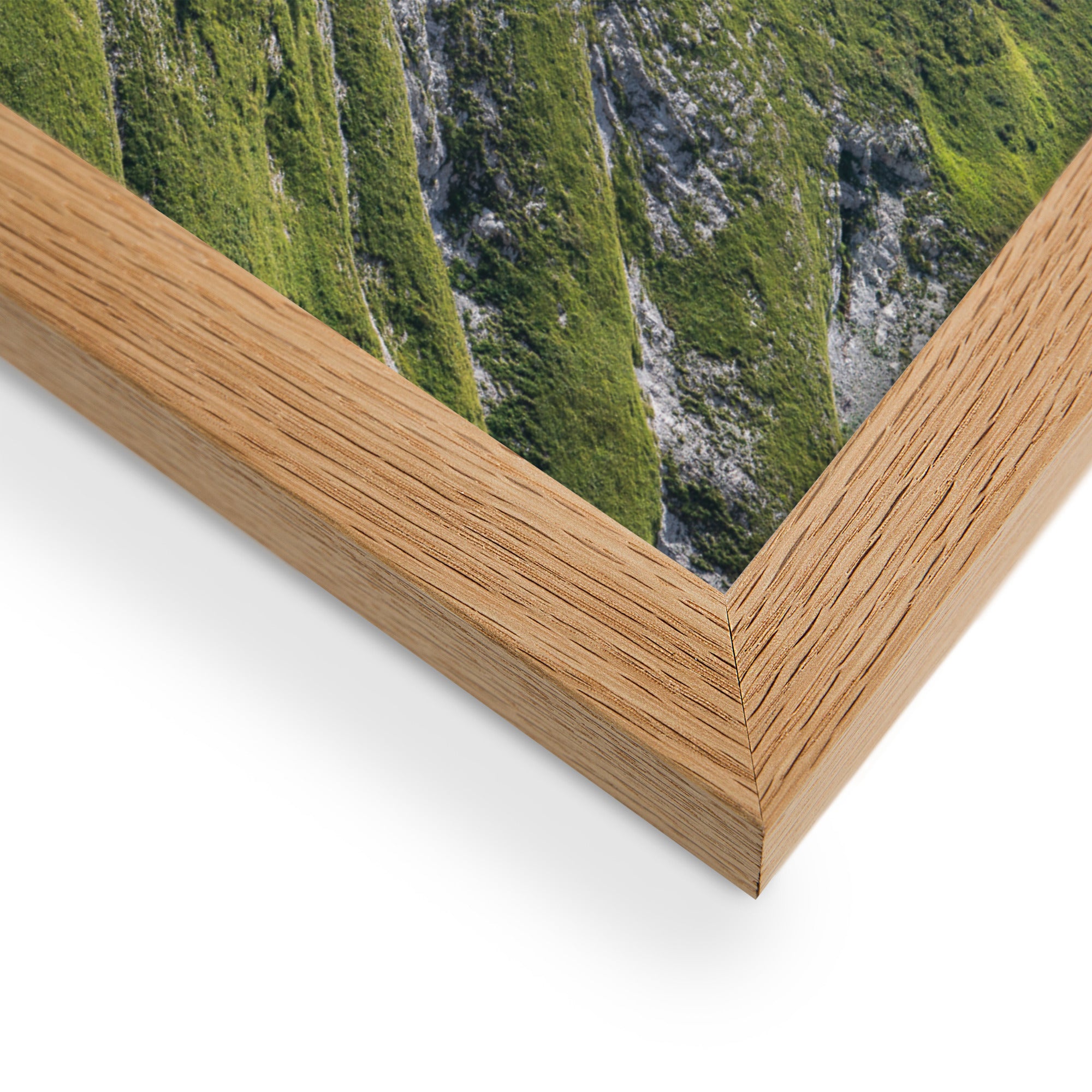 Vue panoramique du 'Mamelon Vert' avec sa végétation luxuriante et montagneuse, encadrée en bois de chêne.
