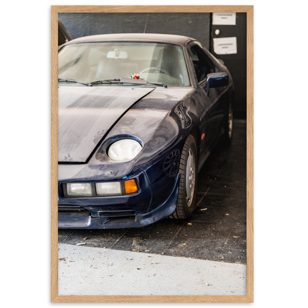 Poster d'une photographie d'une Porsche 928 poussiéreuse stationnée dans un coin discret.