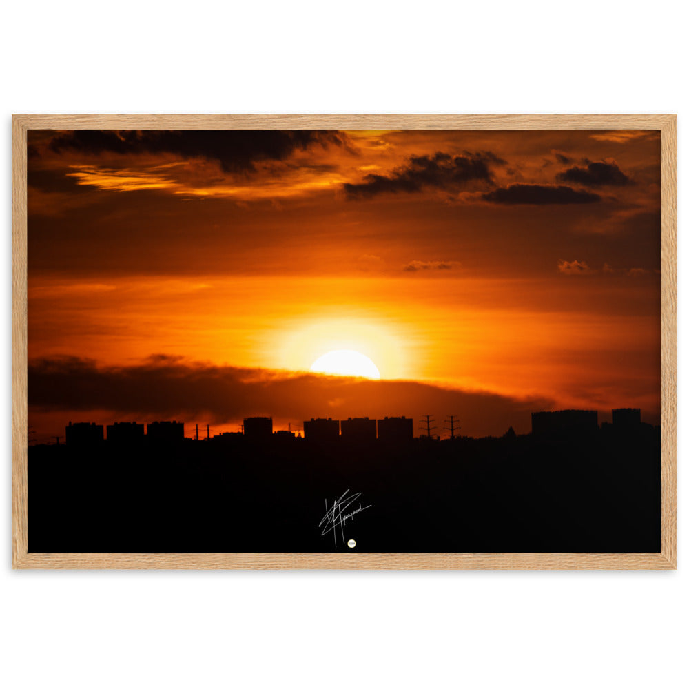 Vue panoramique d'une ville au coucher du soleil, où les bâtiments se découpent majestueusement contre le ciel orangé, évoquant calme et sérénité.