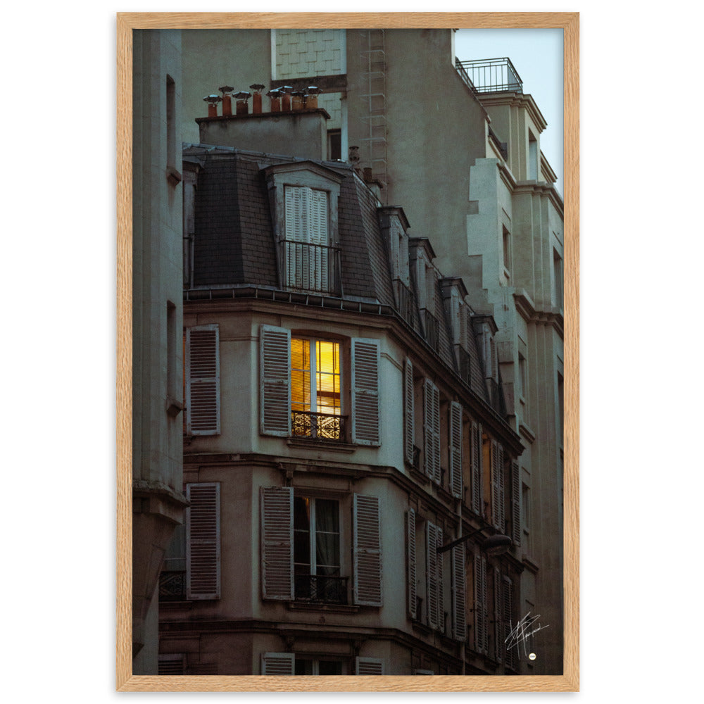 Photographie nocturne d'un bâtiment parisien vintage. Une fenêtre illuminée projette une lumière douce et chaleureuse, évoquant l'intimité d'un foyer parisien.