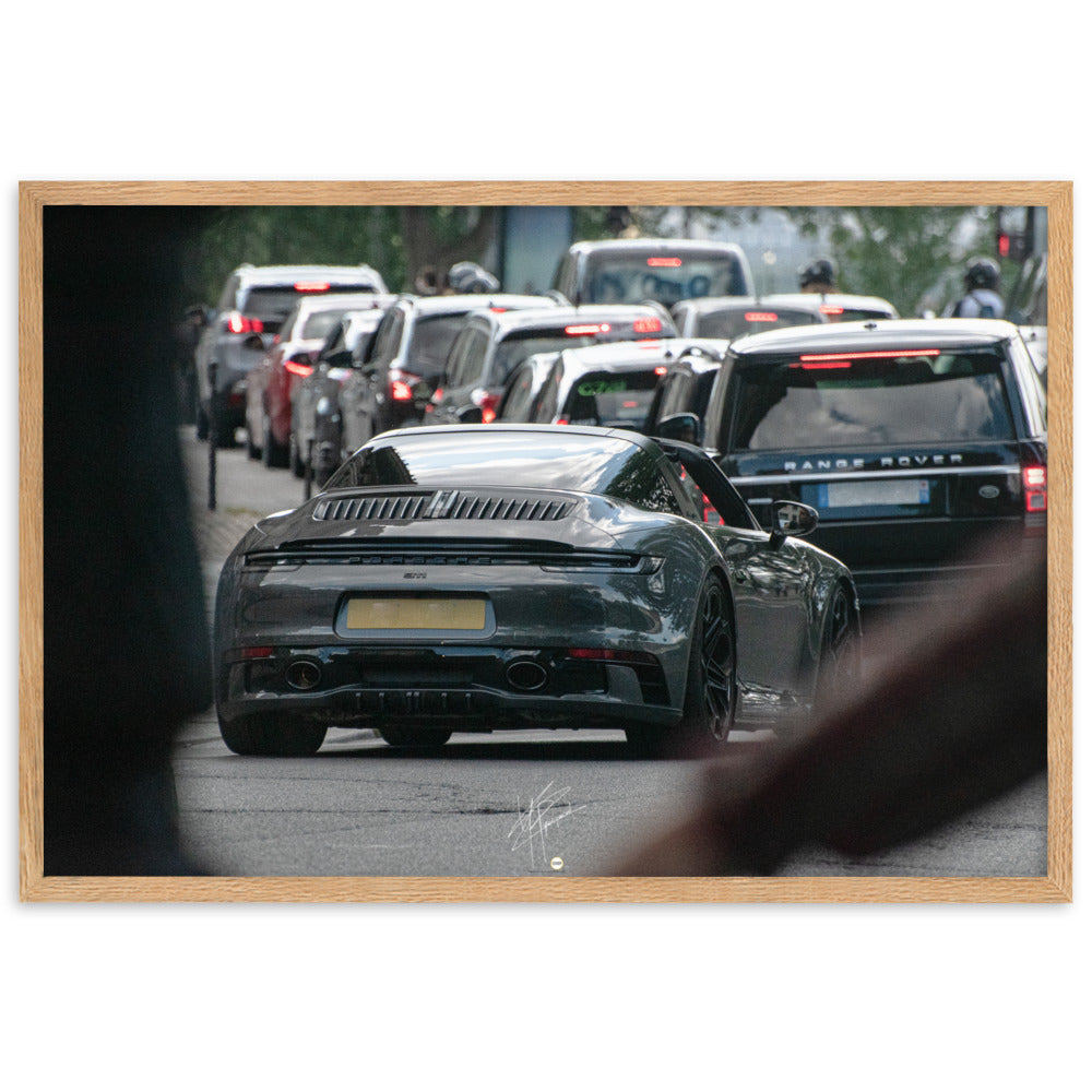 Photographie d'une Porsche 911 Targa vintage naviguant dans la circulation parisienne, suivie d'un Range Rover moderne, capturant une rencontre d'époques et de styles.