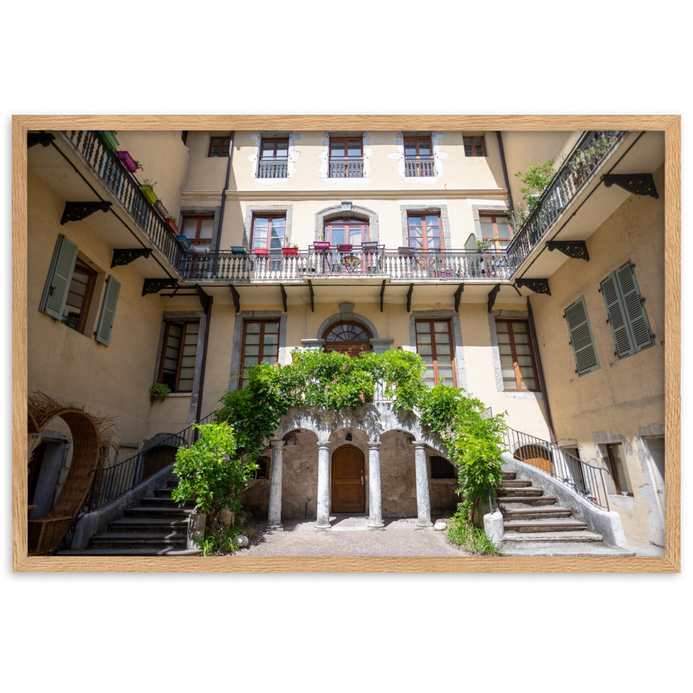 Photographie d'un bâtiment traditionnel italien avec escaliers en spirale et plantes suspendues, encadrée en chêne massif.