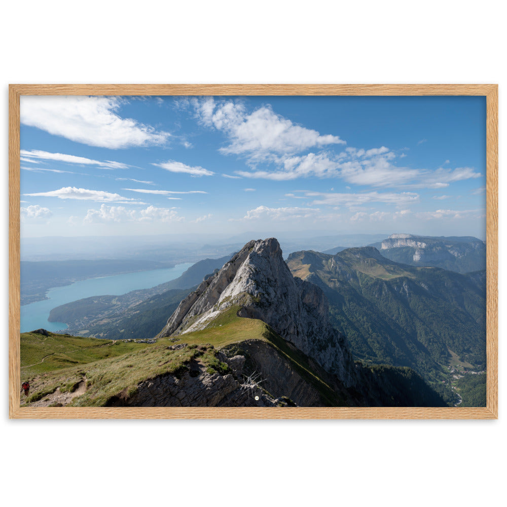 Vue aérienne du Col du Varo avec les montagnes rocheuses en avant-plan et le Lac d'Annecy en arrière-plan, encadré en chêne.