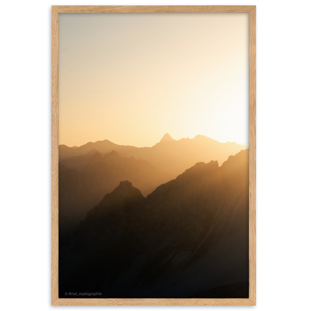 Lever du soleil illuminant des montagnes imposantes, photographié par Brad_explographie, présenté dans un cadre élégant.