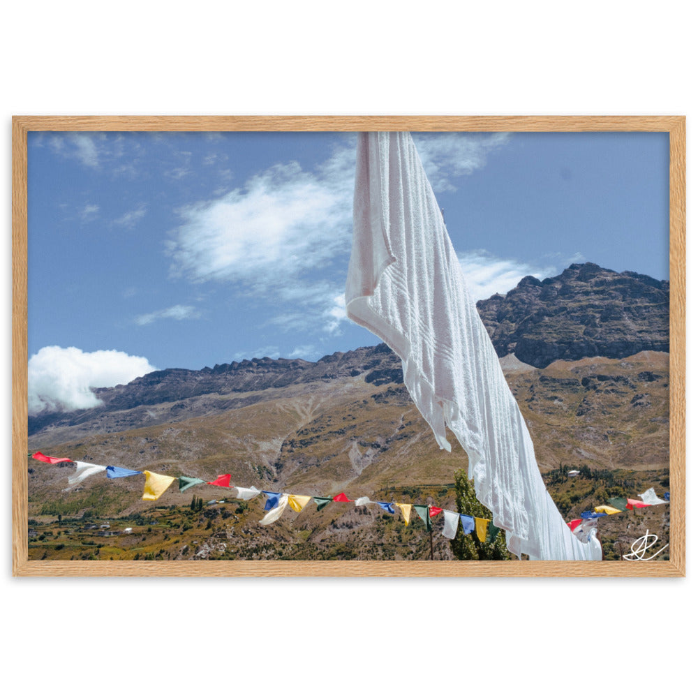 Photographie 'Les drapeaux' par Ilan Shoham, capturant la beauté des drapeaux de prière bouddhistes dans le paysage serein de l'Himalaya, juxtaposant la spiritualité et le quotidien humain.