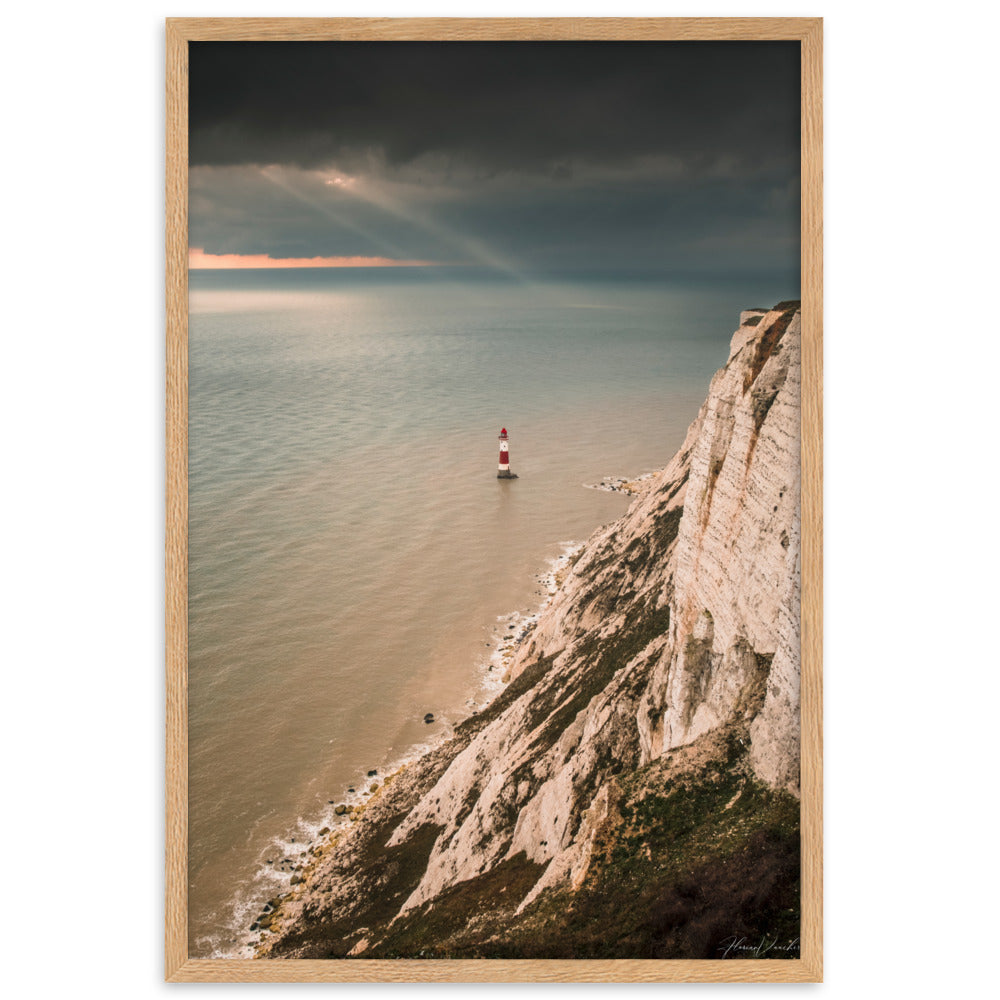 Photographie d'un phare rouge et blanc majestueux face aux vagues et un ciel dramatique, capturée par Florian Vaucher, symbolisant la tranquillité et la persévérance face aux éléments naturels.