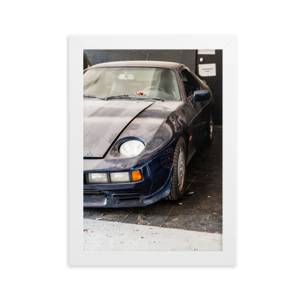 Poster d'une photographie d'une Porsche 928 poussiéreuse stationnée dans un coin discret.