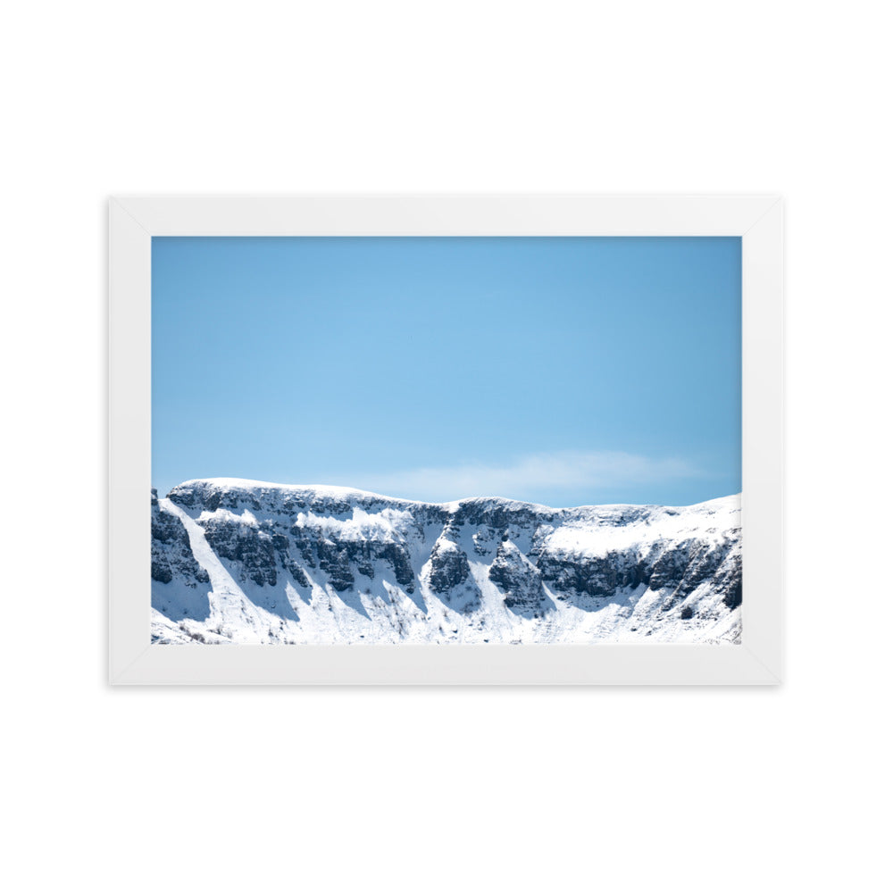 Photographie des montagnes enneigées du Cantal sous un ciel bleu ensoleillé