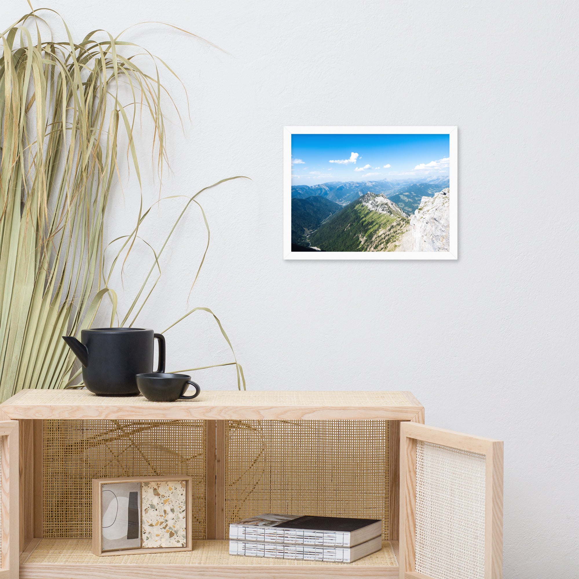 Photographie panoramique des Alpes avec montagnes robustes, vallées verdoyantes, nuages flottants et ciel bleu azur.