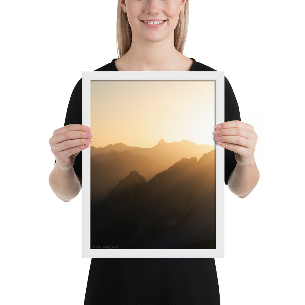 Lever du soleil illuminant des montagnes imposantes, photographié par Brad_explographie, présenté dans un cadre élégant.