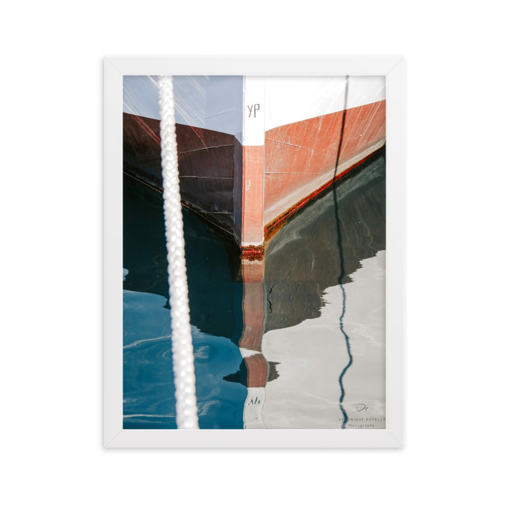 Poster encadré 'Dolce vita' montrant un pittoresque bateau à coque en bois reflétant sur les eaux calmes du port, photographié par Veronique Botella.