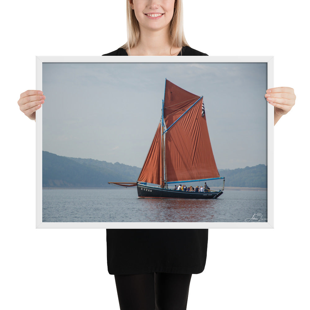 Affiche 'Le cap sur Brest', une image maritime pittoresque par Adrien Louraco, montrant un bateau à voile rouge naviguant à travers le port de Brest, combinant beauté naturelle et charme culturel breton dans une œuvre d'art mural inspirante.