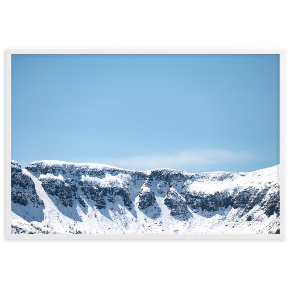 Photographie des montagnes enneigées du Cantal sous un ciel bleu ensoleillé