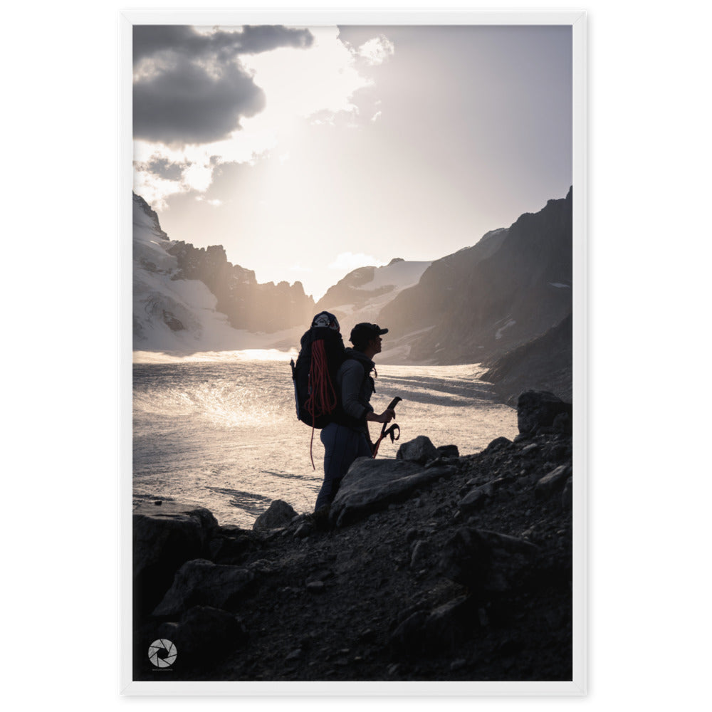 Photographie d'un randonneur face à l'immensité d'un glacier sous les rayons du crépuscule, capturée par Brad Explographie, symbolisant la confrontation entre l'homme et la nature.