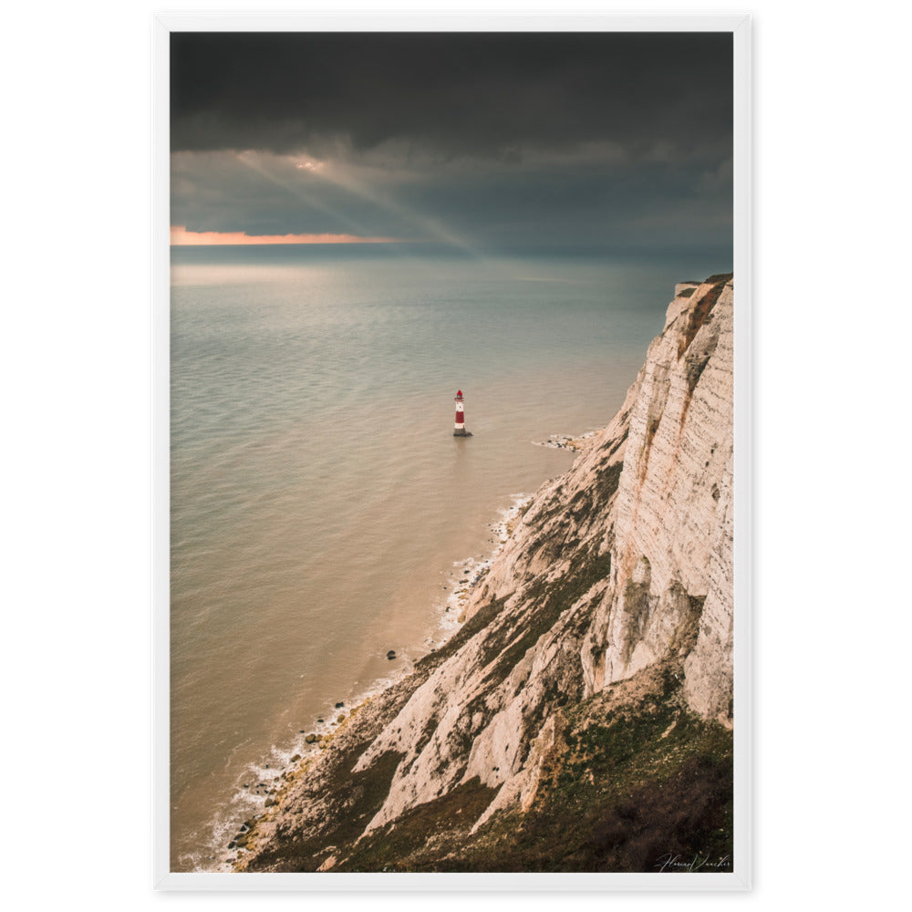 Photographie d'un phare rouge et blanc majestueux face aux vagues et un ciel dramatique, capturée par Florian Vaucher, symbolisant la tranquillité et la persévérance face aux éléments naturels.