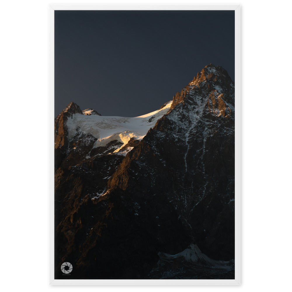 Photographie des montagnes au crépuscule, par Brad_Explographie, illustrant les sommets enneigés éclairés par les derniers rayons du soleil.