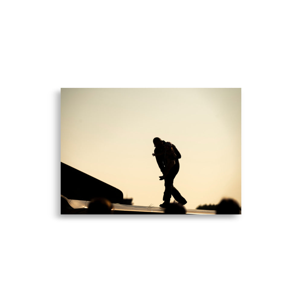 Photographie 'Héroïque' montrant un pilote et une fillette partageant un moment émouvant sur l'aile d'un avion, sous une lumière jaune orangée, capturé par l'artiste Yann Peccard.