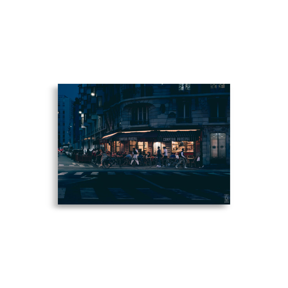 Photographie nocturne d'un café parisien animé, capturée par Galdric Sibiude, reflétant l'ambiance chaleureuse et le charme de la vie urbaine à Paris.