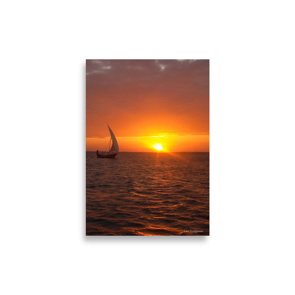 Photographie d'un dhow traditionnel naviguant sur l'océan au coucher du soleil, capturée par Léa Scappini, dépeignant une scène de tranquillité et de solitude apaisante.